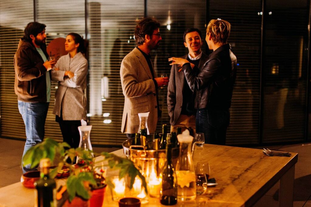 Várias pessoas conversando em uma confraternização, fazendo networking.
