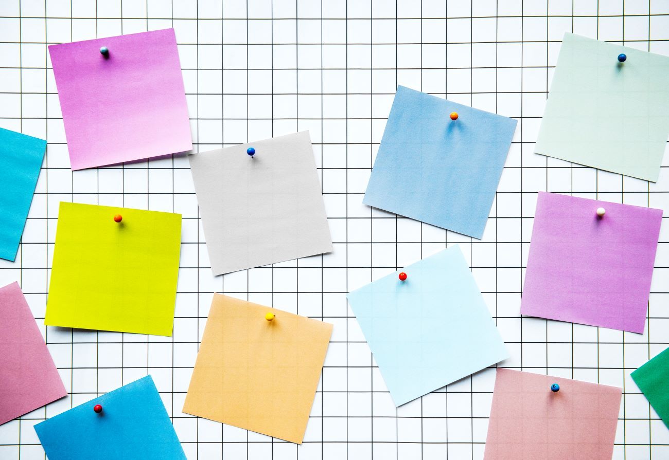 Dois funcionários parados, lendo os recados do mural de avisos da empresa