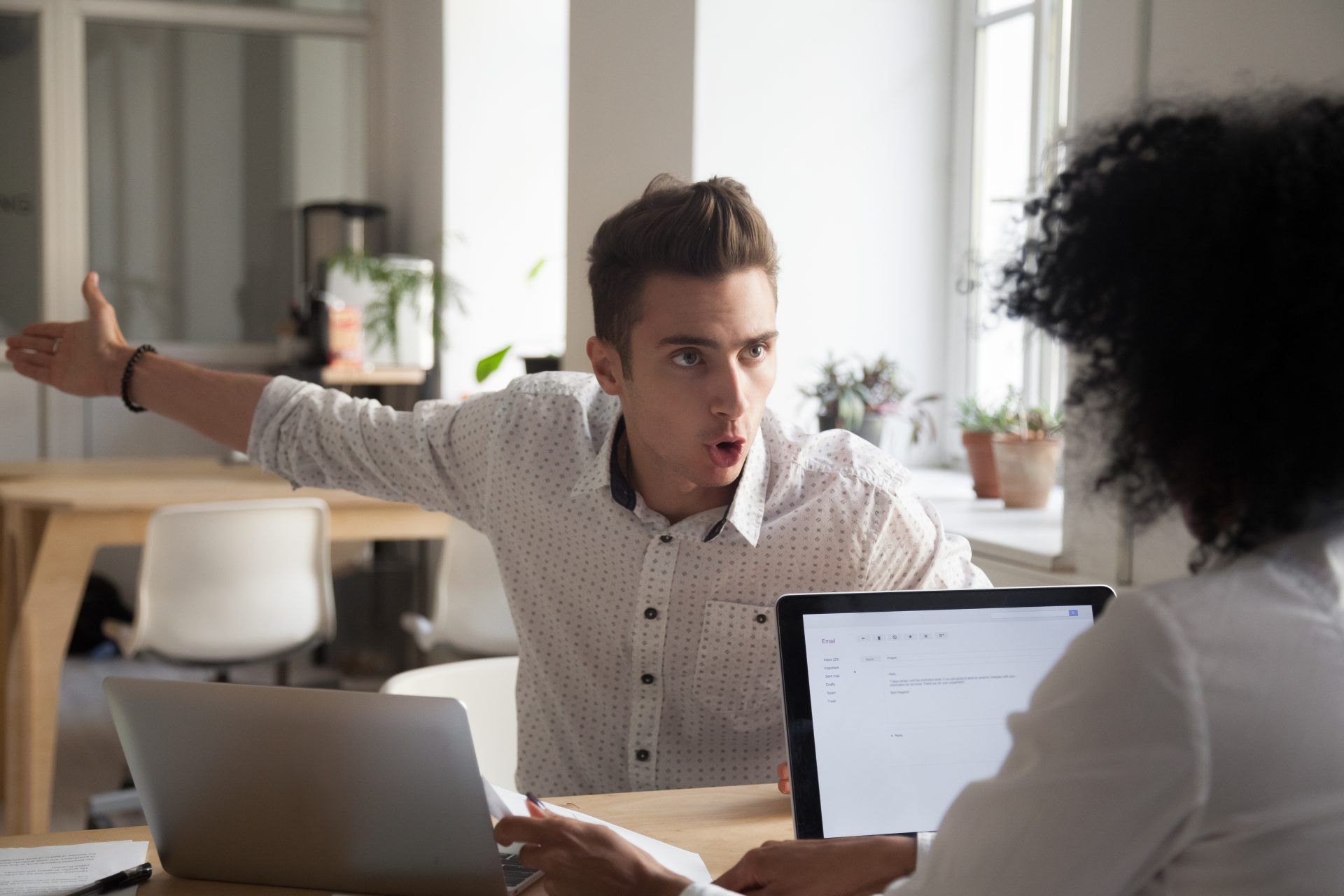 Um homem praticando uma comunicação violenta com seus colegas de trabalho.
